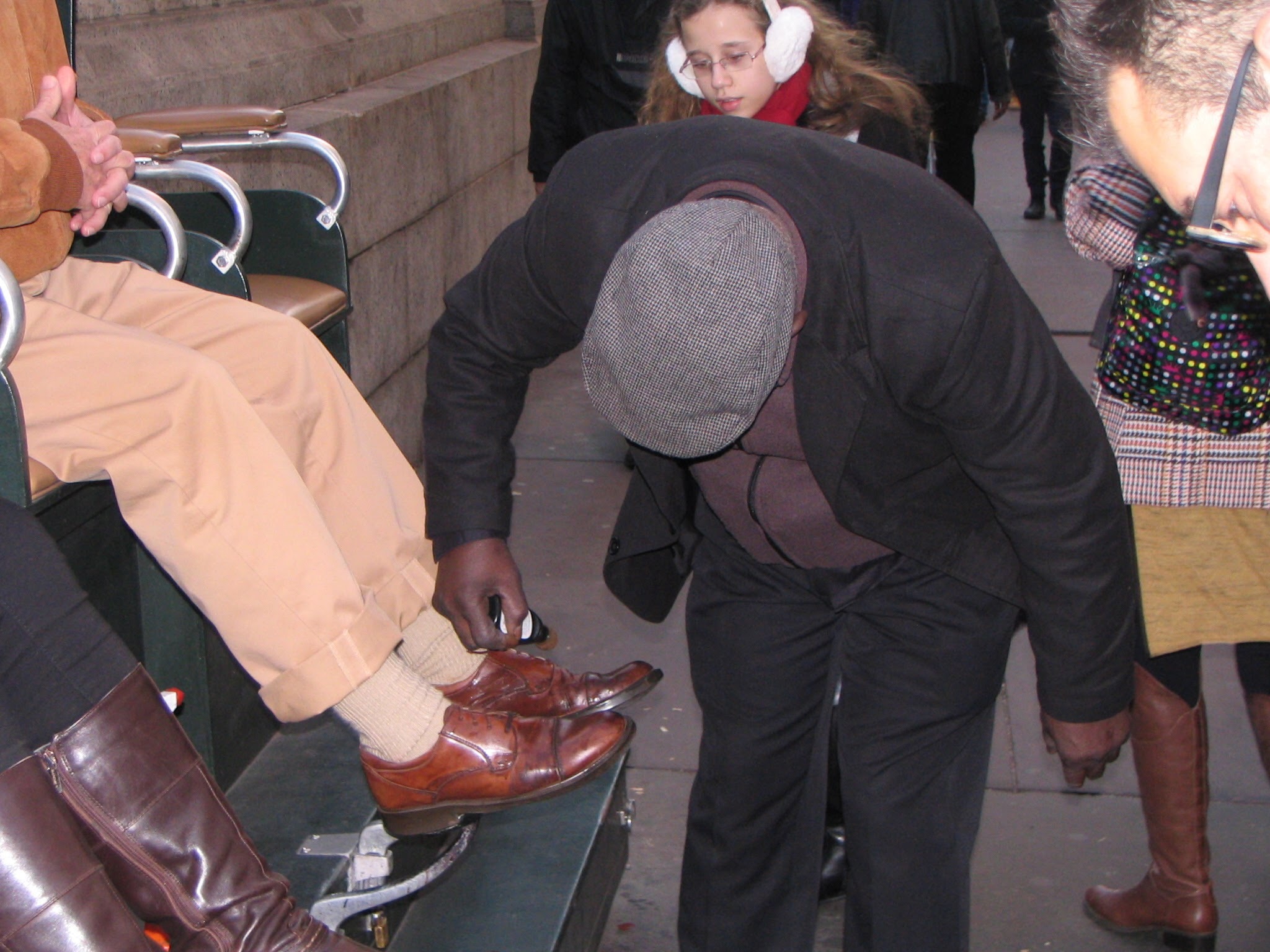Shoeshiner buffing shoes outside New York Public Library